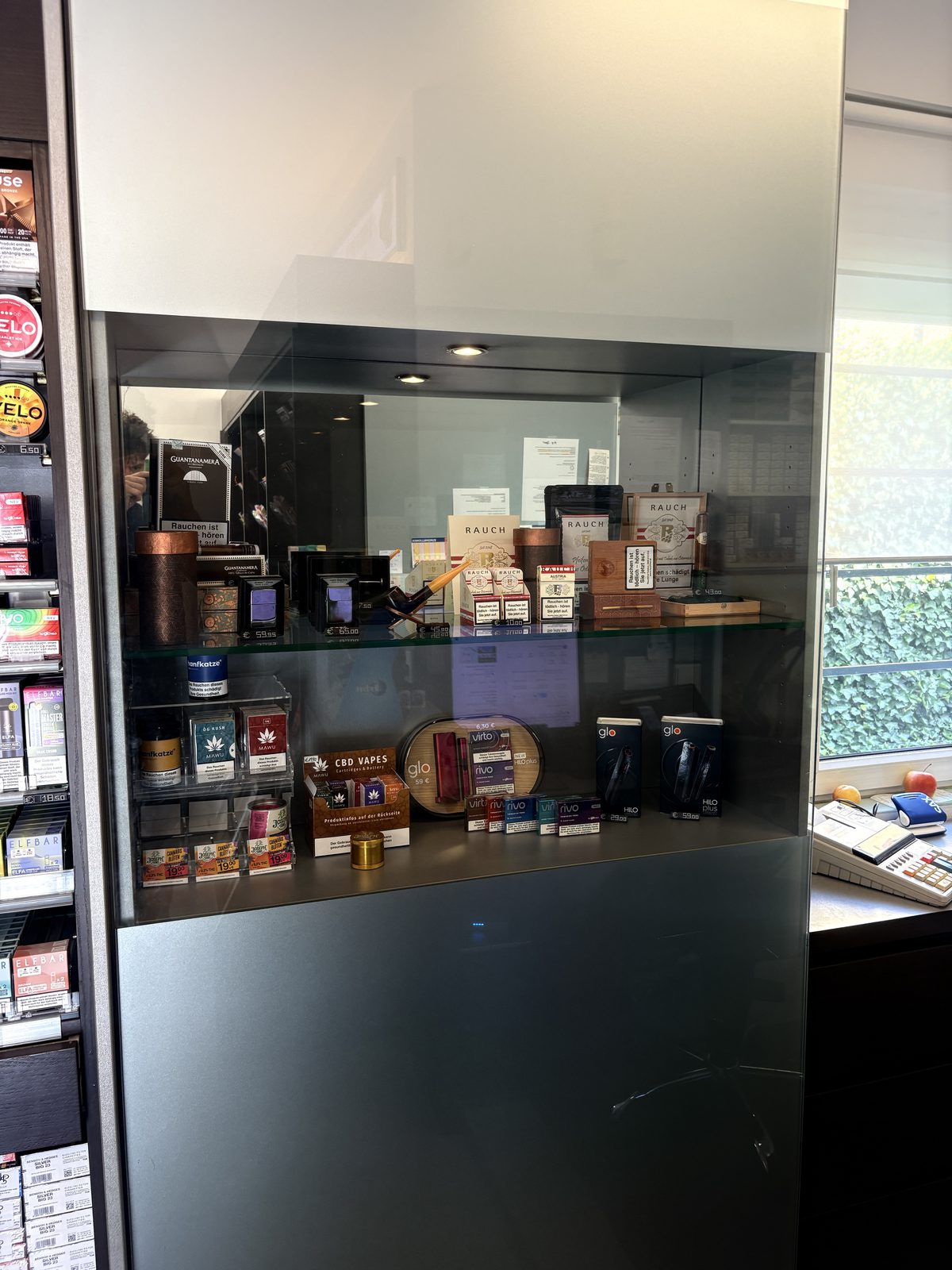 Glasvitrine mit Zigarren, Pfeife und Tabakerhitzern